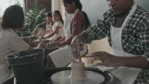 Students Crafting Clay on Pottery Wheel in Art Class