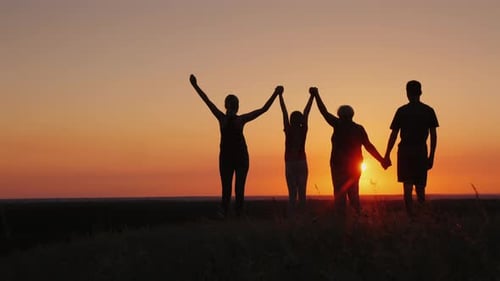 A Group of People Gleefully Raise Their Hands Up the View From Behind