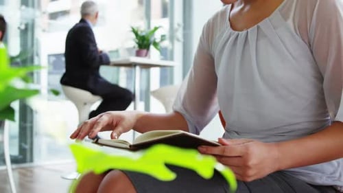 Woman Reads Book in Airy Modern Office