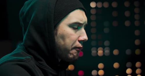 Close-up de um hacker usando um moletom tenta invadir um sistema de segurança para roubar