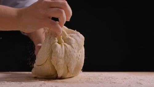 Hands Kneading Dough for Baking on Table