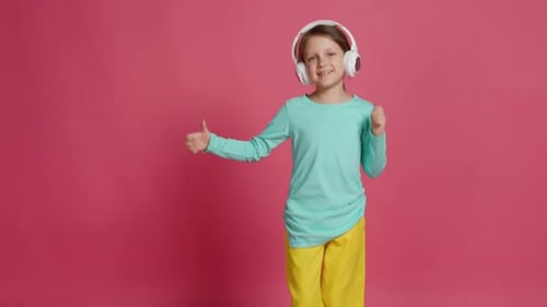 Young Girl Dancing with Headphones on Pink Background