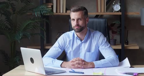 Portrait of a Millennial Professional Businessman Sitting at the Office Table Look Away