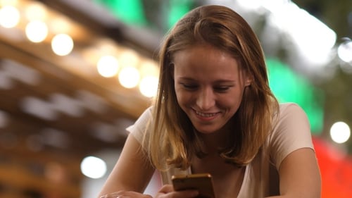 Cheerful Woman at The Bar Reading Funny Messages on Her