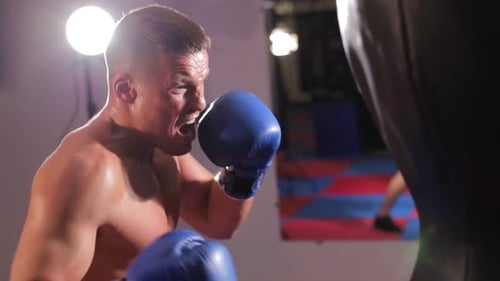 Man Boxing With Punching Bag at Gym