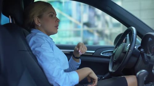 Frustrated Businesswoman Takes Off Glasses, Sitting in Car, Upset With Failure
