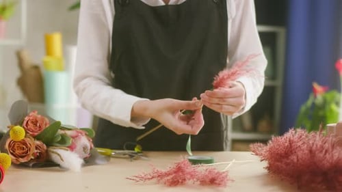 Florist Arranging Pink Flowers in Flower Shop