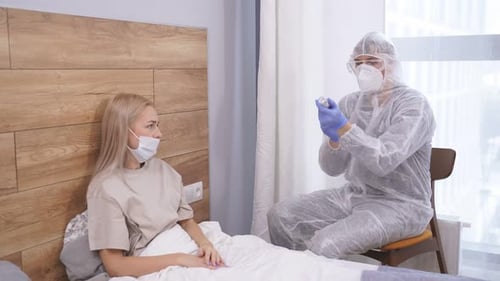 Nurse in Suit Going to Make Vaccination in the Shoulder of Patient at Home