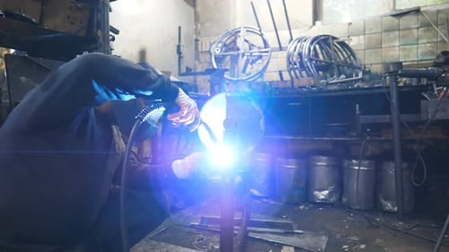 Arbeiter im Schutzmaskenschweißen Metallbau in der industriellen Produktion