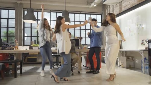Excited Young Professionals Celebrate in Modern Office
