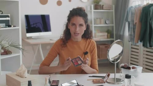 Woman Applies Makeup at Table with Mirror