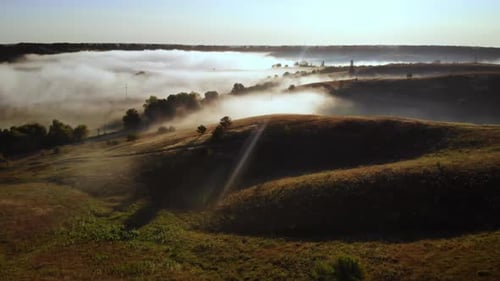 Drone Flies Into the Fog Over Rolling Hills
