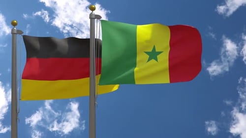 Flags of Germany and Senegal Waving Together Against Blue Sky