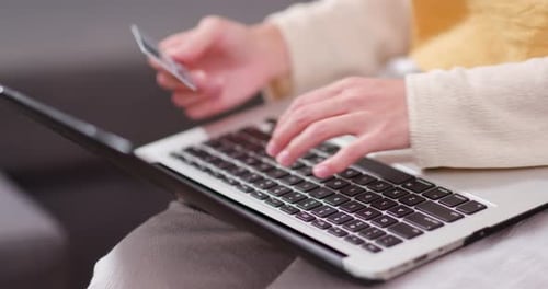 Woman Types on Laptop Holding Credit Card