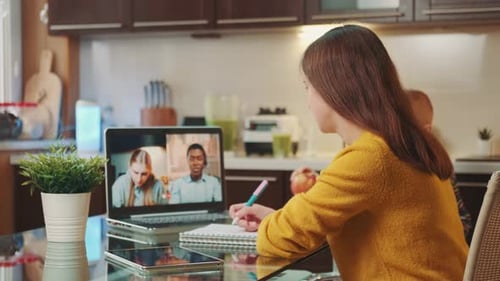 Femme ayant une vidéoconférence en ligne avec une équipe multiraciale pendant que son fils lui donne une pomme