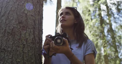 Woman Photographer Shooting Photos with Vintage Camera in Sunny Forest