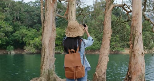Woman Taking Picture of Lake with Smartphone