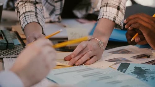 Close-up Hands of Multiethnic Marketing Company Colleagues Discussing Work at Office Table