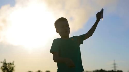 Child with Paper Airplane at Sunset