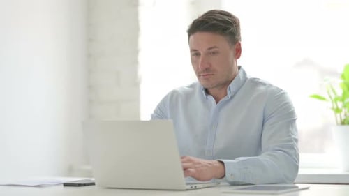 Man Working on Laptop in Office