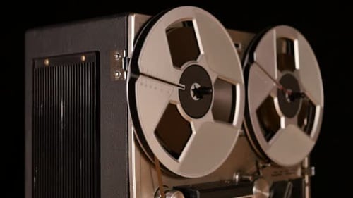 Vintage Reel to Reel tape recorder playing music close up of reel