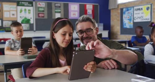 Girl and Teacher Learning with Tablet in Classroom