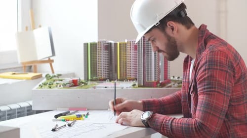 Young Man Making Building Model in Office