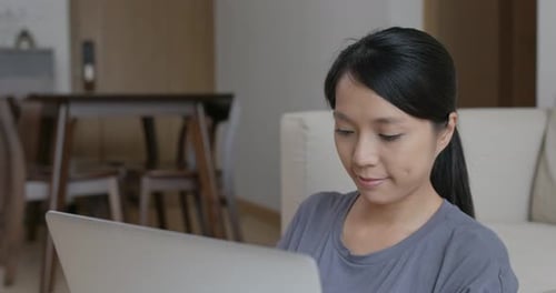 Young Woman Uses Laptop at Home