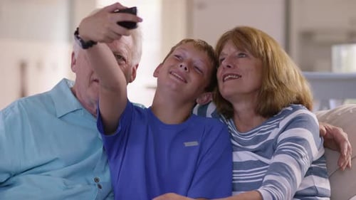 Grandparents Smiling With Grandson Taking Selfie on Phone