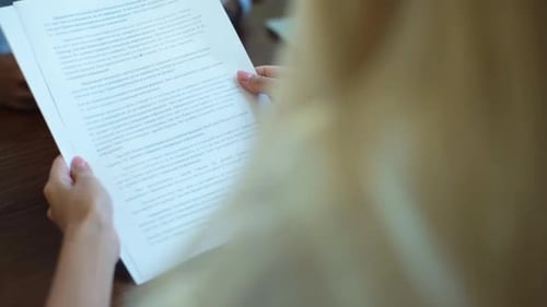 Closeup Back View of Unrecognizable Businesswoman Reading Documents Sits at Table with Male Business