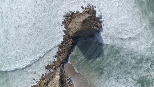 Aerial View of Ocean Waves Crashing on Rocky Shore