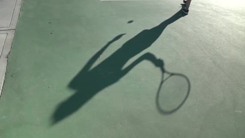 Shadow of Tennis Player Hitting Ball Outdoors