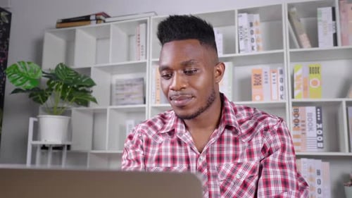Man Works at Laptop in Home Office