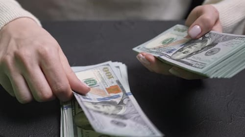 Woman Counting Stack of Hundred Dollar Bills