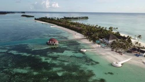 Drone shot, moving backwards. Maldives resort, port side, paradise on earth. 4K