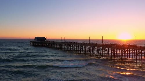 Wide aerial view of the Newport Beach pier at sunset