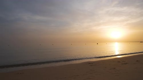 Calm Sea Shore with Crushing Waves on Sandy Beach at Sunrise