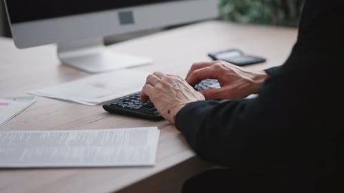 Nicht wiederzuerkennender reifer männlicher Angestellter, der an Laptop-Händen arbeitet und auf der
