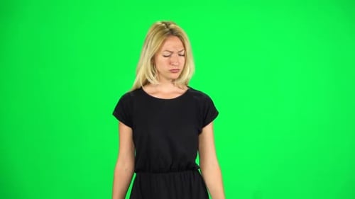 Pensive Woman Is Walking on a Green Screen at Studio. Slow Motion