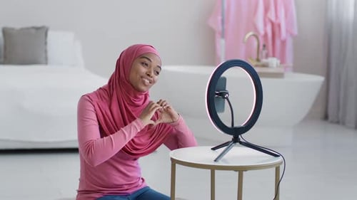 Popular Muslim African American Lady Blogger in Hijab Streaming Online Showing Heart Gesture to