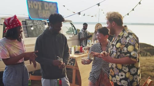 Friends Enjoying a Beachside Hot Dog Celebration