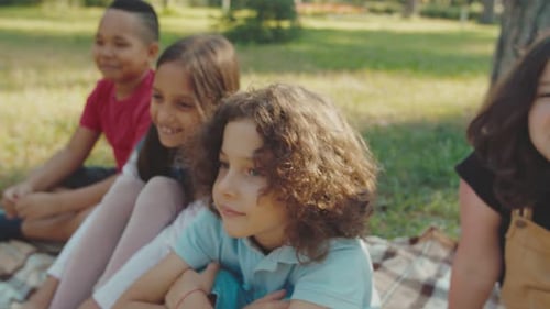 Smiling Children Laughing Together on Picnic Blanket