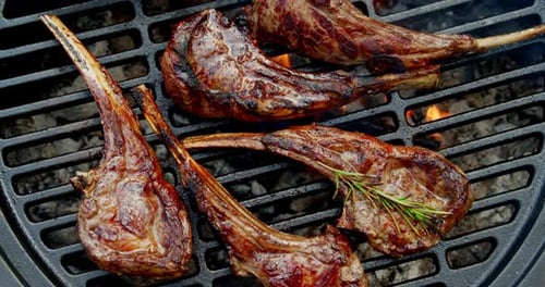 Costillas de cordero listas con romero a la parrilla.