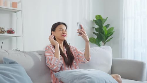 Smiling Woman Video Chats on Smartphone at Home