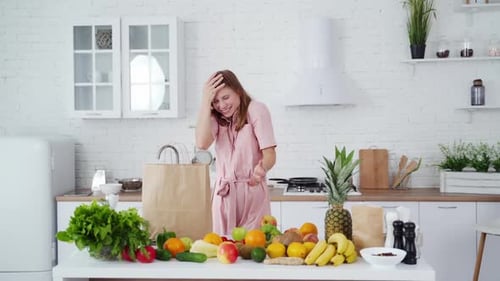 Young woman in modern kitchen. Portrait of a smiling happy girl throwing apples in kitchen