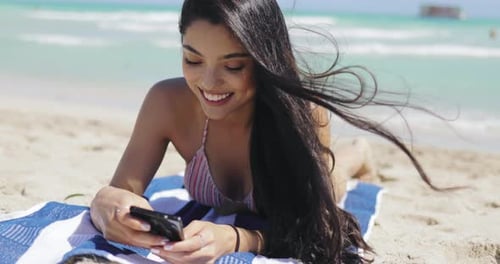 Pretty Girl Using Phone on Beach