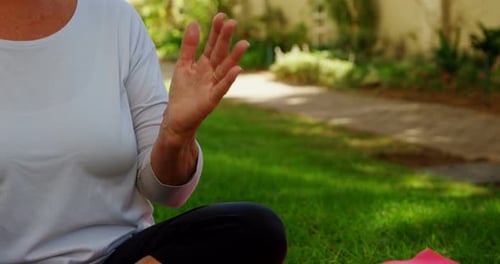 Senior woman performing yoga in garden 4k