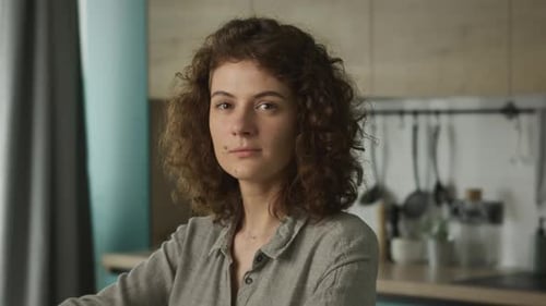 Contemplative Woman with Curly Brown Hair Inside