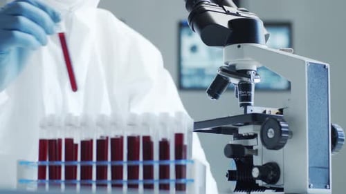 Medical Lab Technician Analyzing Blood Sample with Microscope