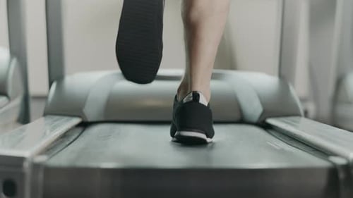 Nahaufnahme Athletische Füße Laufen auf dem Laufband im Fitnessstudio